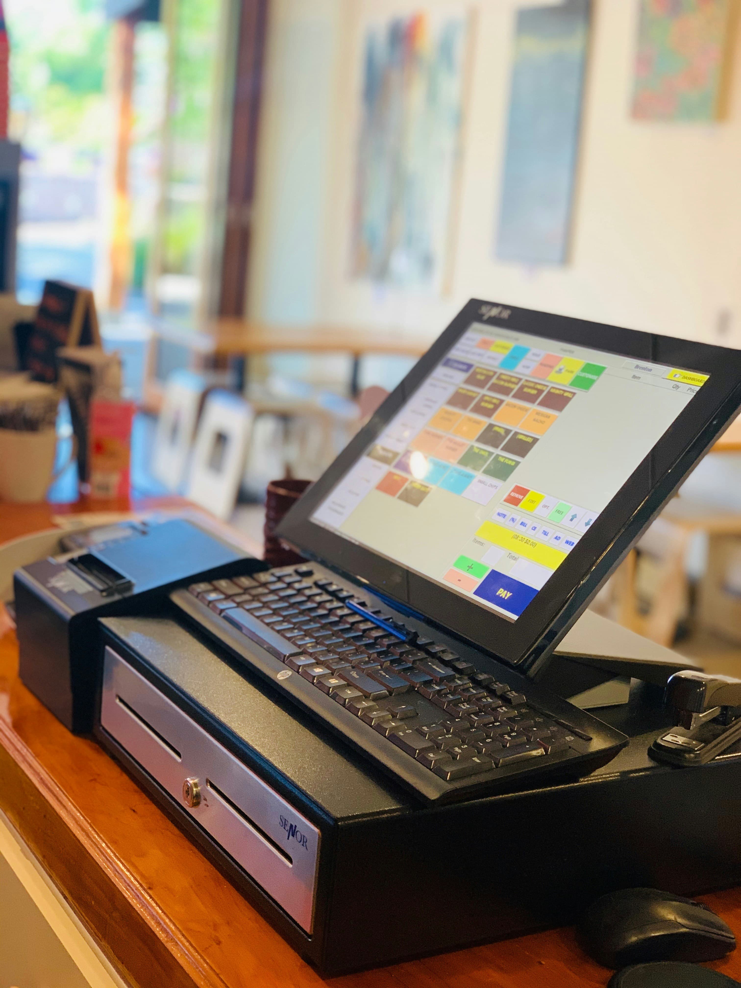 Shopkeeper using a Point of Sale (POS) system at the counter